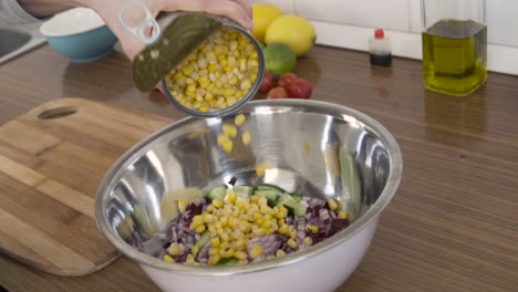 Salat-In-Der-Küche-Zubereiten-Mais-In-Eine-Mit-Gemüse-Gefüllte-Schüssel-Geben