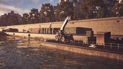 a cargo ship docked at a river port with a forklift on board