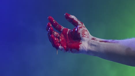 video of hand covered with blood moving over smoke on black background