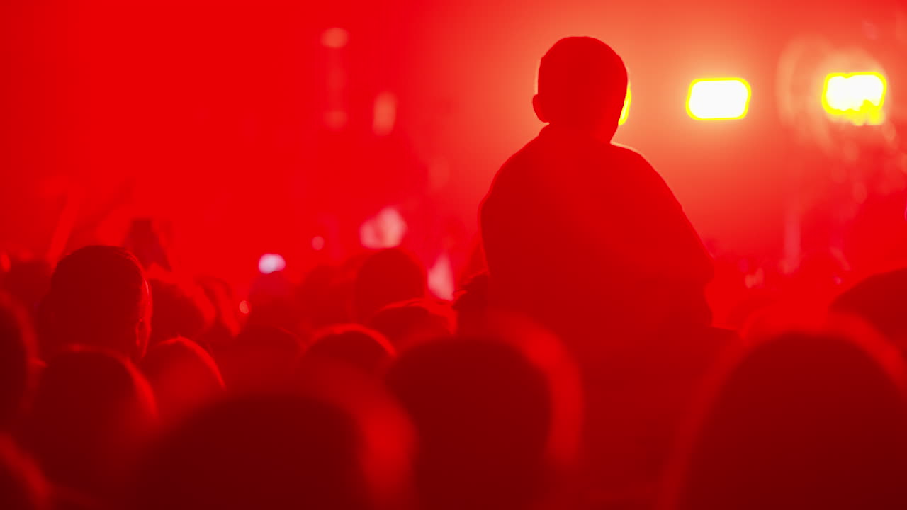 La folla del concerto con l'illuminazione rossa