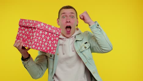 cheerful teen young man opening gift box, great happiness amazement, satisfied with best present