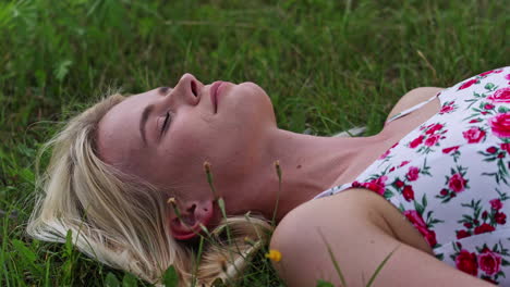 young woman breathes fresh air while lying on the grass