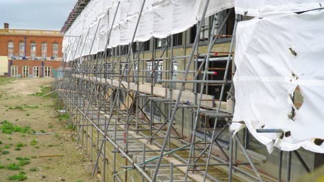 scaffolding on the wall of a big building close to sea