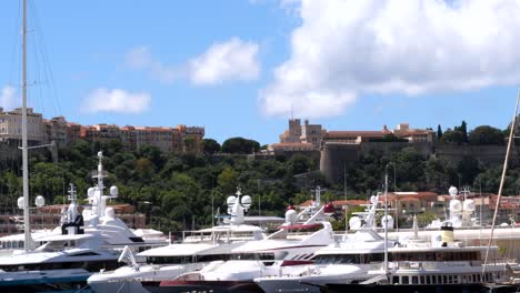 Wide-shot-of-luxury-yachts-at-marina-and-Prince-Palace-Building-on-hilltop