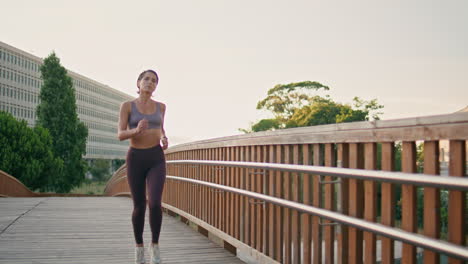 atleta motivado corriendo el puente de la mañana. mujer haciendo entrenamiento de cardio corriendo