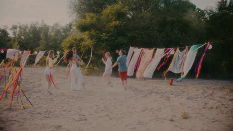 Young-friends-grooving-around-couple-dancing-bachata-at-beach