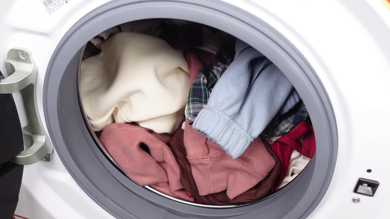 Closeup of a washing machine with clothes inside