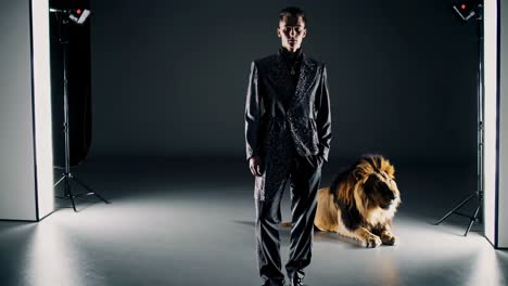hombre en traje con un león en un escenario de estudio