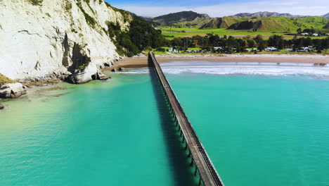 hermosa vista aérea del largo muelle, la playa de arena y los acantilados empinados