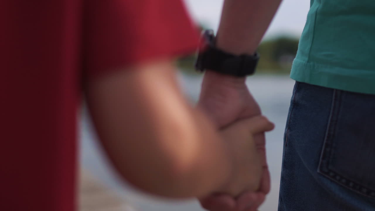 Father and Son Holding Hands by the Lake