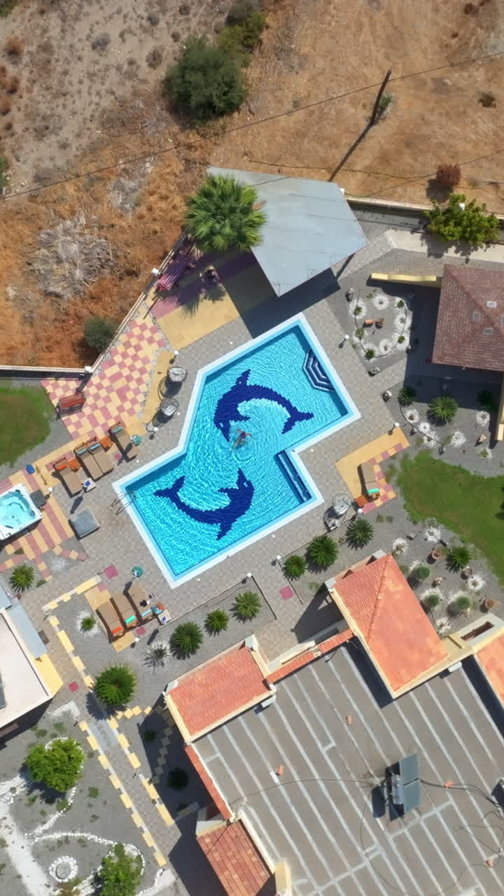 9:16 droneoptagelse i fugleperspektiv af en turkis pool ved en middelhavsferievilla