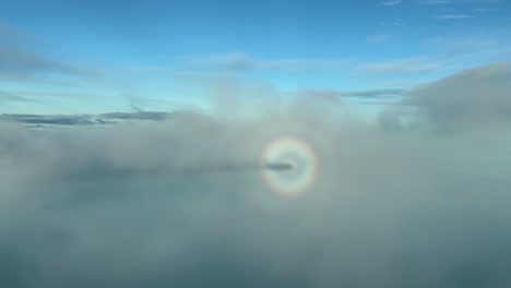 aerial view of the halo and the shadow of a jet flying across the clouds with rare visual effects arriving to mallorca island in spain