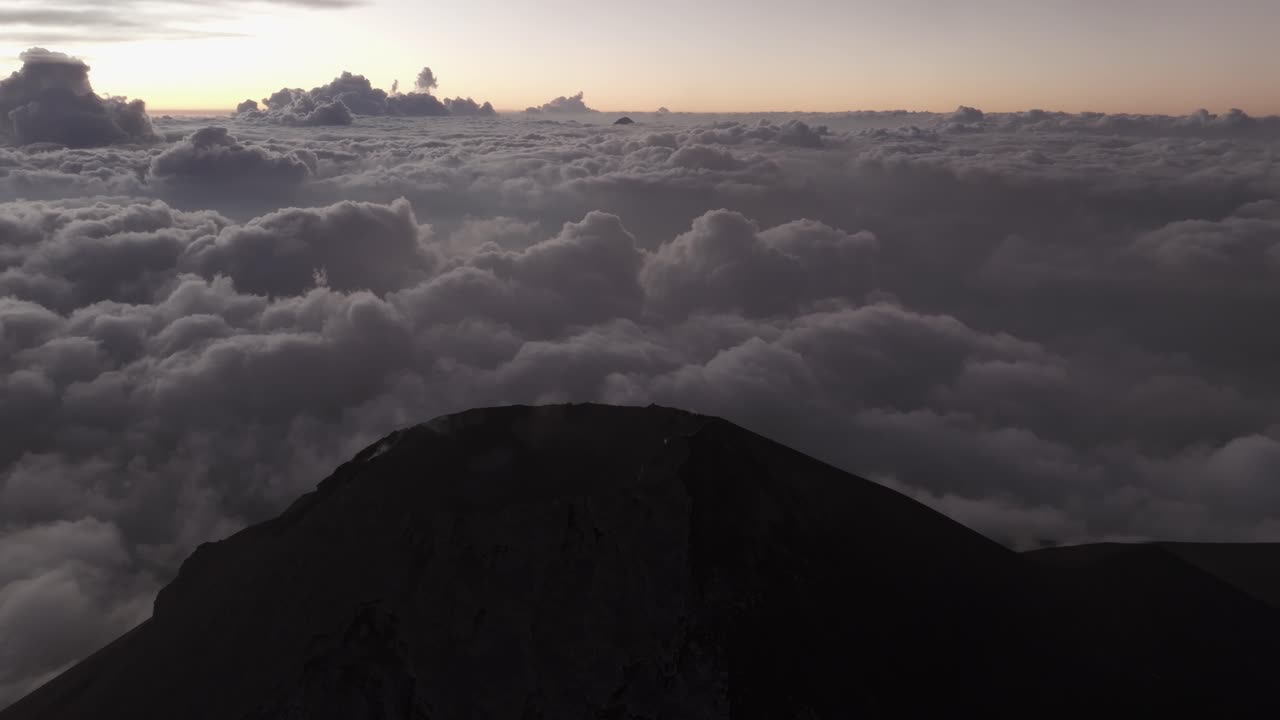 Vista aerea del Volcán de Fuego in piena modalità eruttiva con fumo denso che domina il paesaggio vulcanico