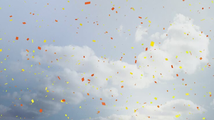 Falling colorful confetti animation over cloudy sky background