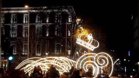 nighttime parade with illuminated float and crown