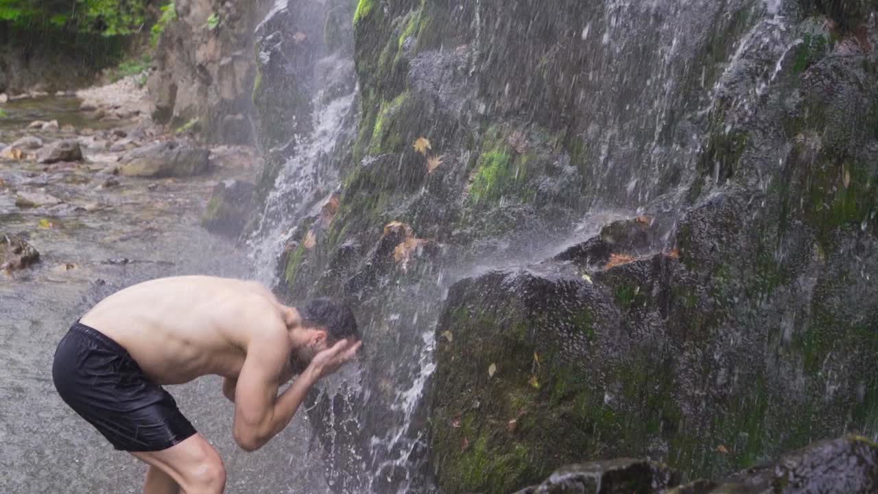 강인한 남자가 폭포  ⁇ 에서  ⁇ 어. 슬로우 모션.