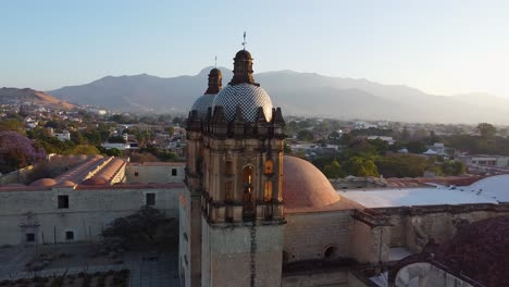 aerial of impressive catholic church in oaxaca with red domes and towers