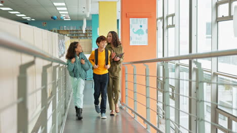 students and teacher walking in school hallway