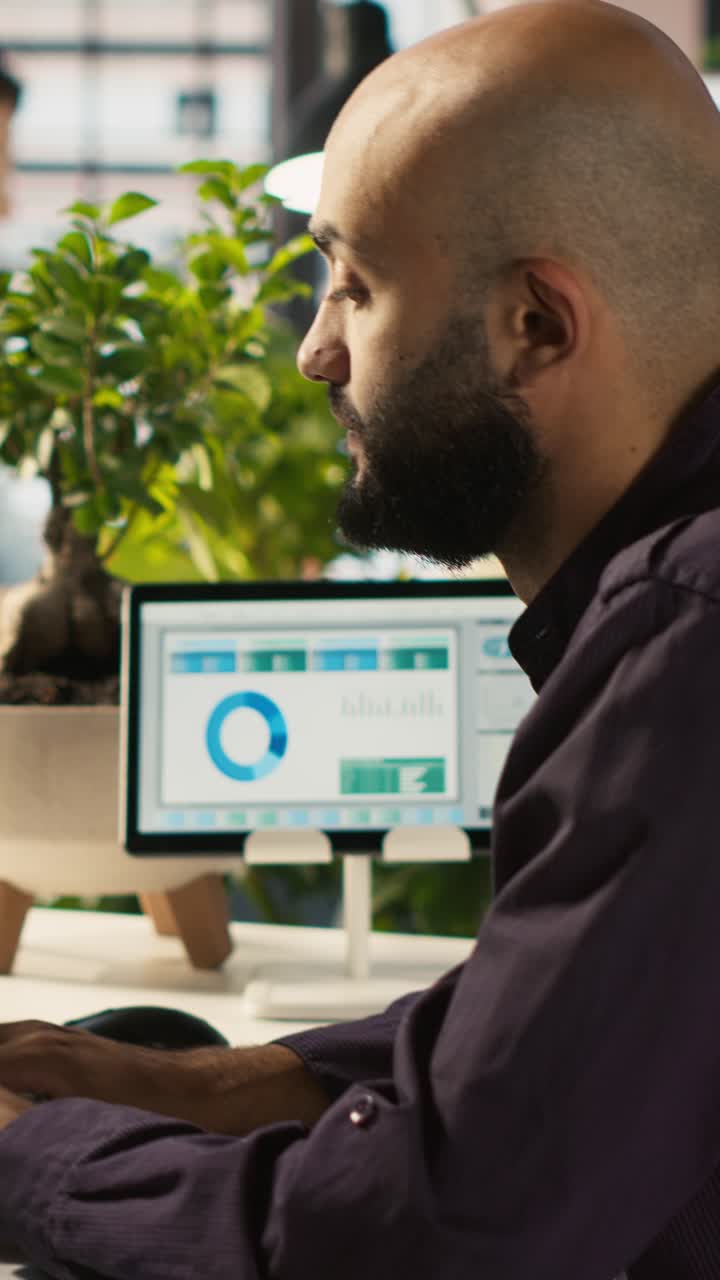 Vertical video Employee editing documents on desktop computer at office desk