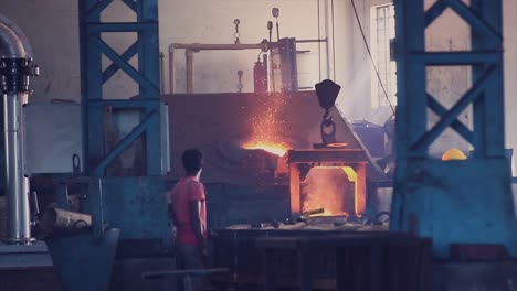 water molten metal being poured from the crucible into the sand mold