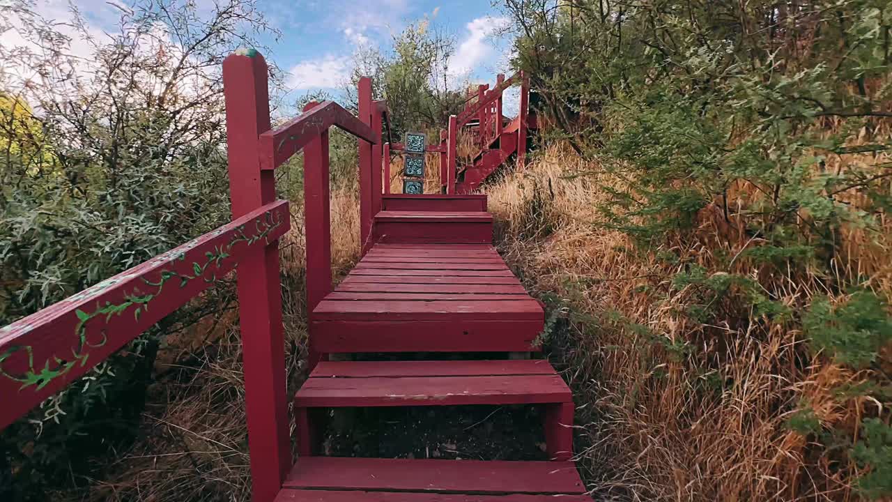 escaleras de madera rojas y pasarela a través de un paisaje
