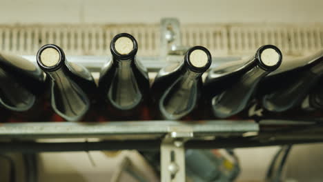 wine bottles closed with a cork stopper move along the conveyor belt view from above