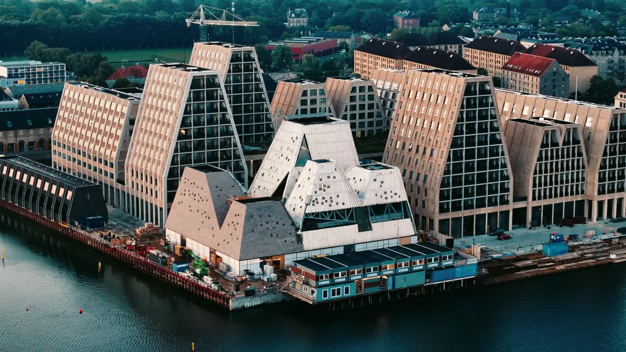 Fast retreating aerial view of Papiroen buildings at sunrise with glowing reflections in Copenhagen