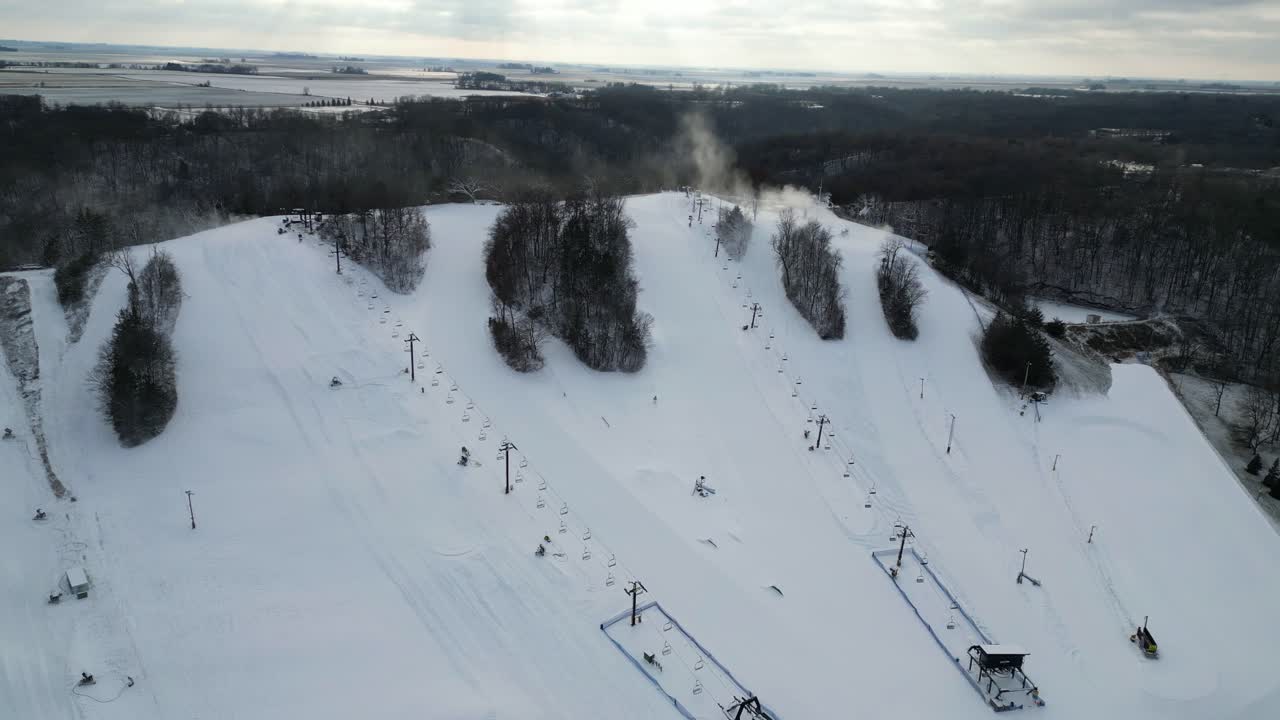 A drone shot of Seven Oaks Ski Resort in Iowa, showcasing its snow-covered slopes and surrounding natural beauty.