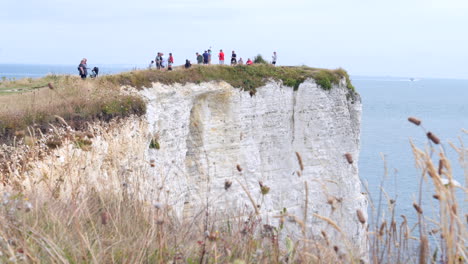 people on a white cliff enjoying the view at old harry rocks slomo