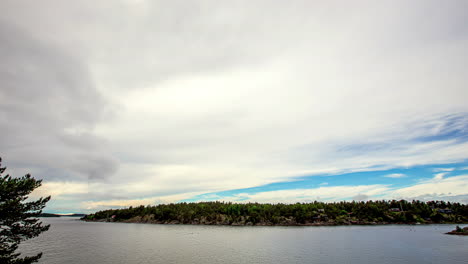 It-is-a-visually-pleasing-spectacle-as-one-immerses-in-the-captivating-view-of-moving-clouds-gliding-through-the-blue-sky,-offering-a-scenic-view-of-the-serene-lake