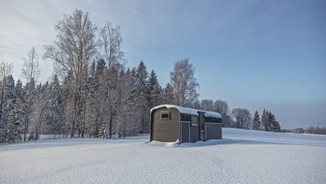 lonely small cabin near a forest in dead cold winter with thick pile of snow