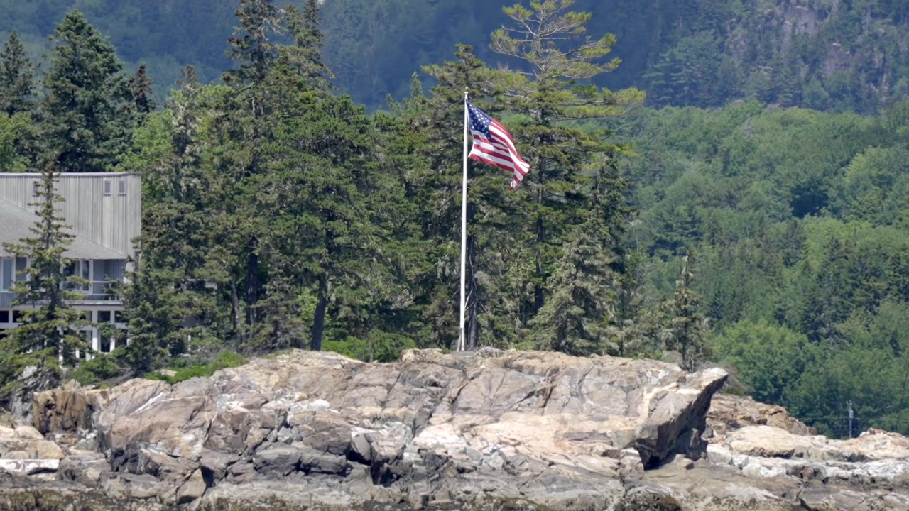 Bandiera americana su costa rocciosa a Great Harbor, Mount Desert, Maine