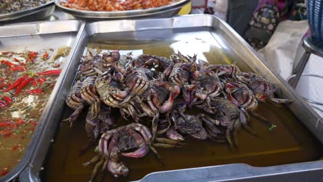 Asian-raw-seasoned-seafood-crab-sashimi-at-food-market-booth-documentary