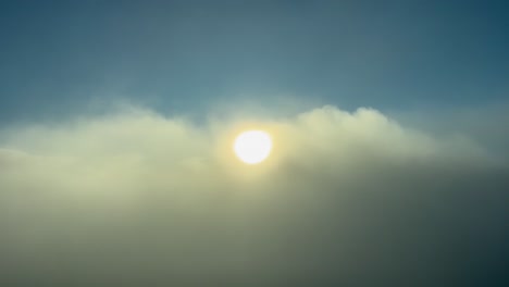 amazing aerial view from a jet cockpit while flying over the clouds with the sun ahead just after sunrise