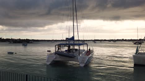 a shot from mainland of a catamaran leaving the pier at sunset