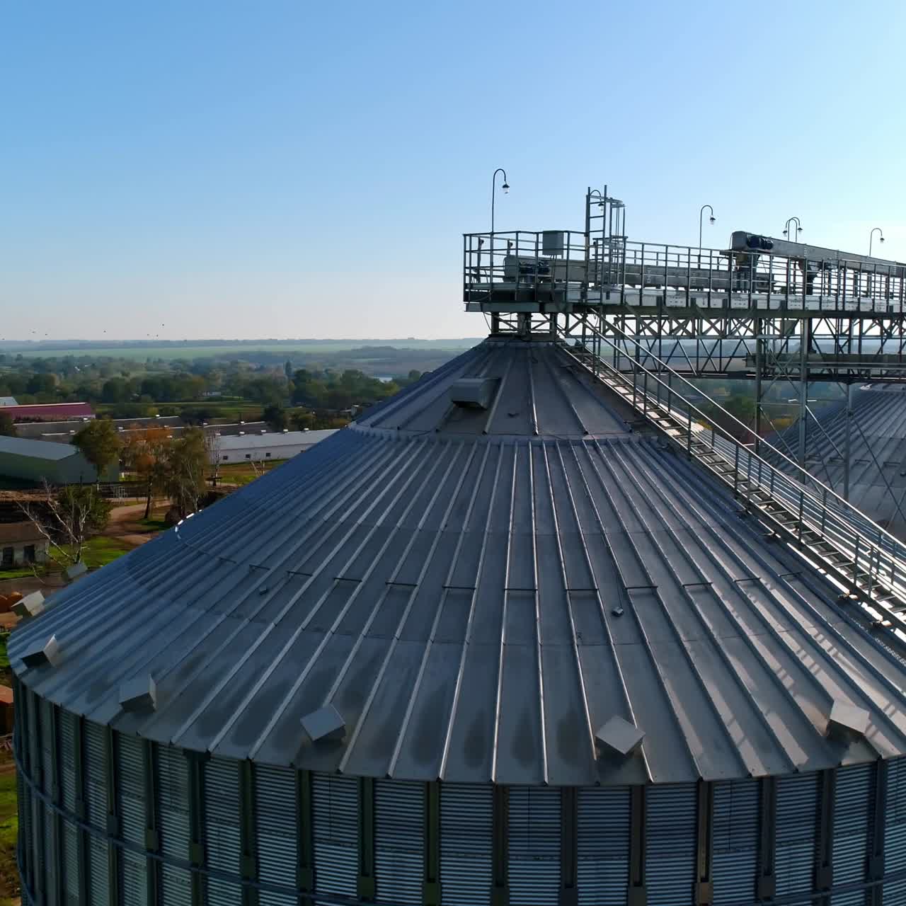 Metal elevator for crop. Silo for storing grain in the countryside. Exterior of large storage tanks for agricultural products. View from above.