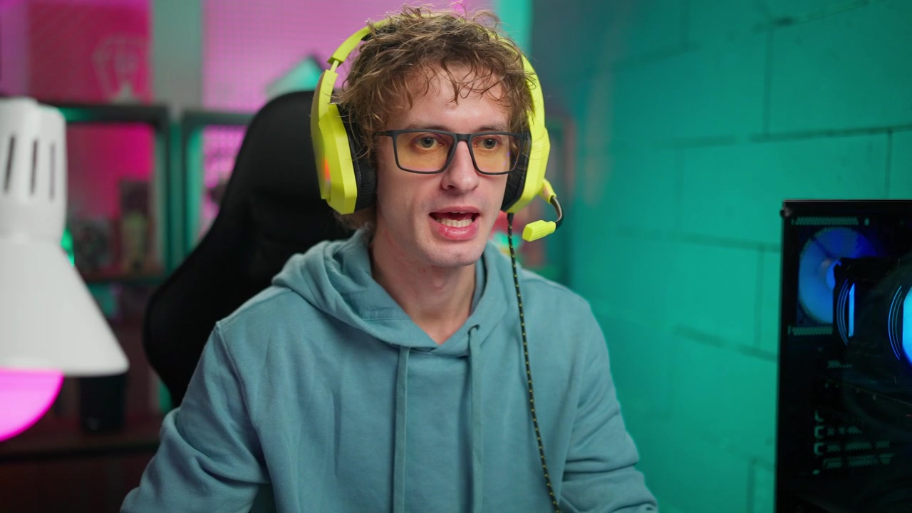 Giovane gamer che parla e sorride in una stanza illuminata al neon