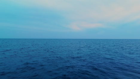 Calm ocean scene with a pastel sky at dusk, soft blues and warm tones blending together