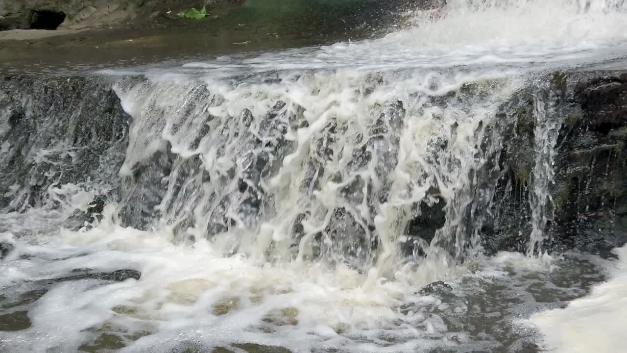 Peaceful woodland forest splashing rapid foaming waterfall slow motion flowing paradise wilderness