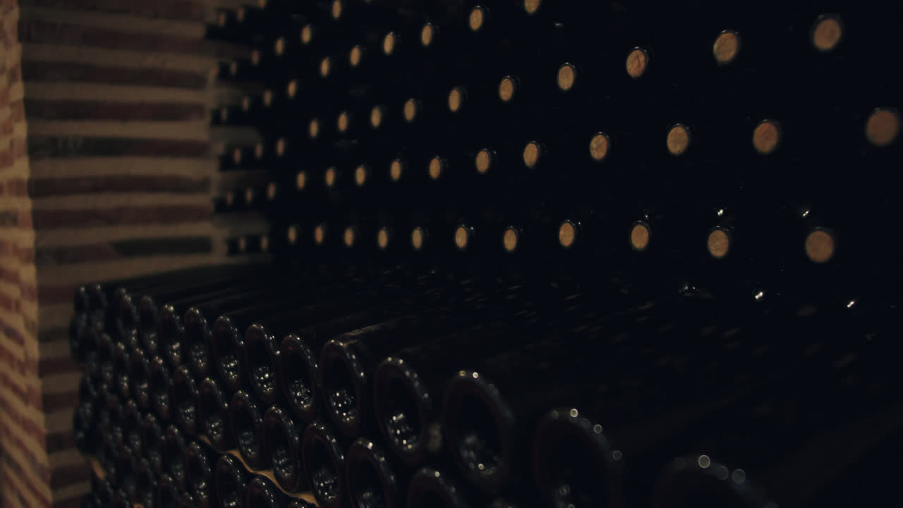 fotografía en cámara lenta de botellas de vino apiladas en un contenedor del metro en burgos, españa con poca luz