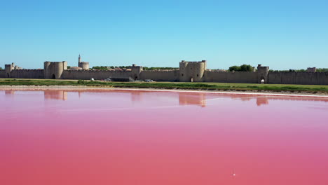 The-historical-town-of-Aigues-Mortes-in-the-Camargue,-France-during-a-sunny-summer-day-which-is-located-next-to-a-pink-salt-lake