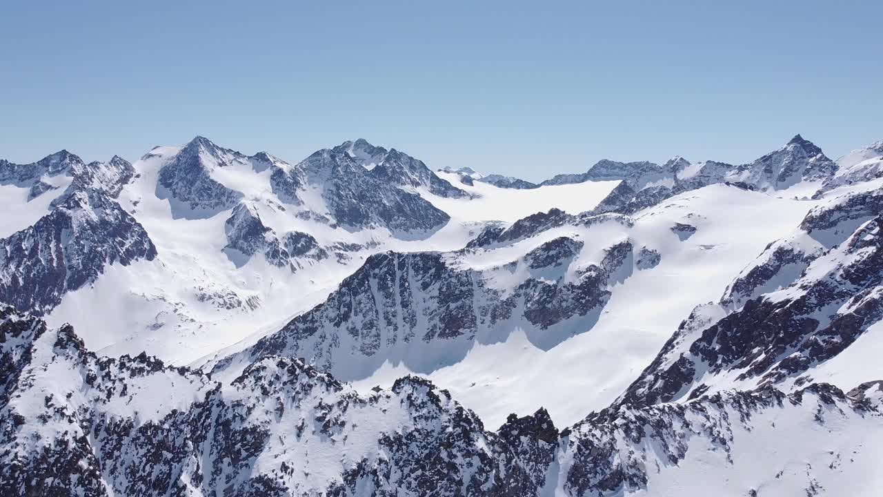Wunderschöne filmische Luftaufnahme von verschneiten alpinen Berggletschergipfeln.