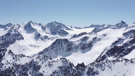 Wunderschöne-Filmische-Luftaufnahmen-Von-Schneebedeckten-Alpinen-Gletschergipfeln