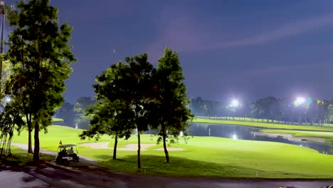 illuminated golf course with trees and water