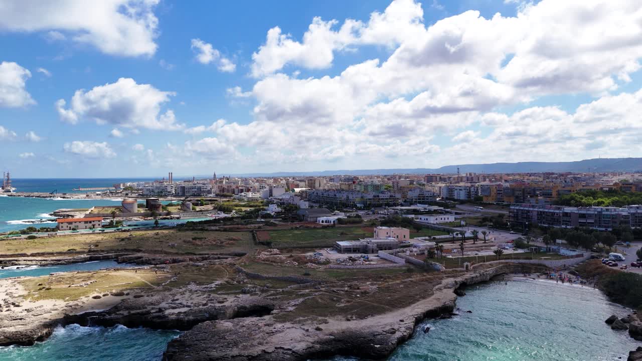 Costa marina rocciosa e panorama urbano di Monopoli sullo sfondo, vista aerea panoramica