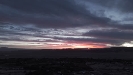 Sideways flying drone shot above San Pedro de Atacama Chile South America on a clear day and purple sky with mountains in the background during sunset LOG