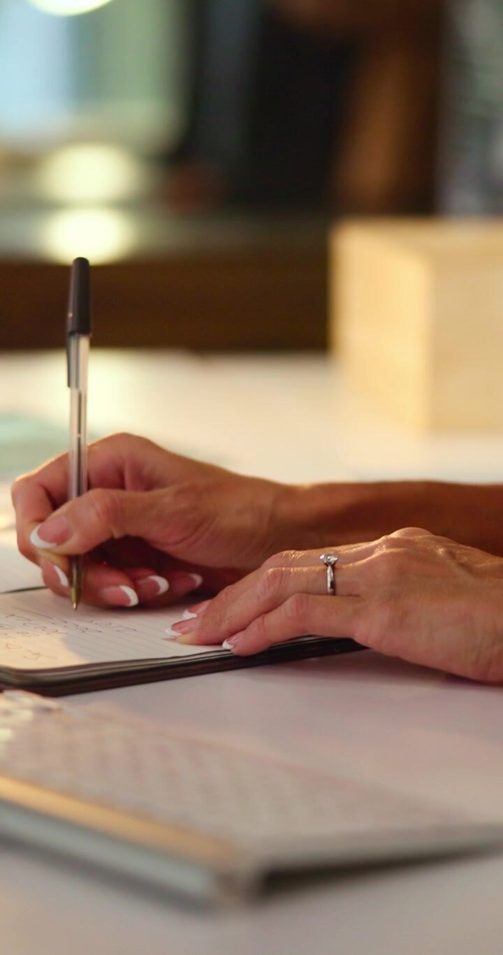 Woman Writing Notes in a Notebook at Her Desk