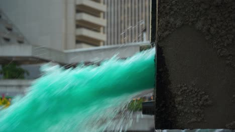 Blaues-Wasser,-Das-Aus-Dem-Rohr-Eines-Abstrakten-Brunnens-Kommt