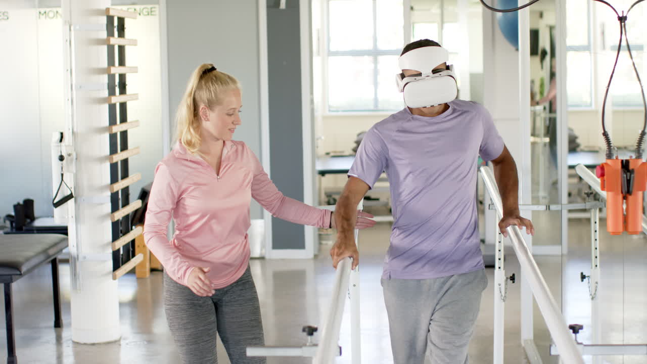 Man in prosthetic leg using VR headset with therapist on parallel bars