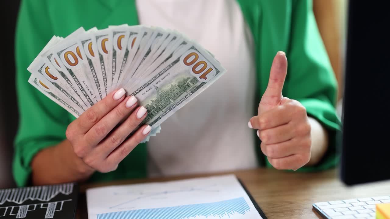 Holding a fan of hundred dollar bills